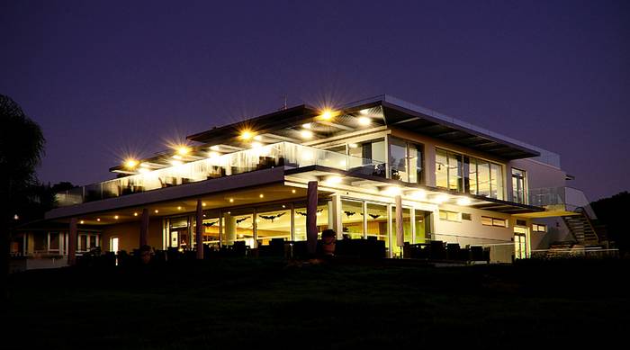Imagem noturna de uma casa com luzes acessas